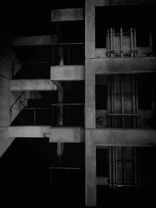 Dark moody shot of apartment building balconies at night