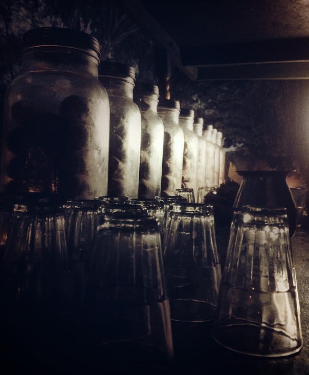 Glass jars and bottles dramatically lit in low light